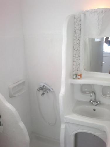 a white bathroom with a sink and a mirror at Giannakas Studios in Platis Yialos Sifnos