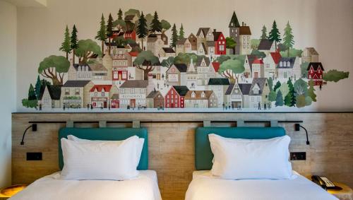 a mural of a town on a wall above two beds at JSL hotel in Taipei