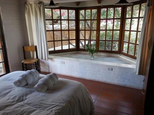 a bedroom with a large window with a bath tub at Apart Hotel Abedules in Puerto Madryn