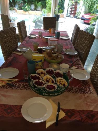 a table with plates and bowls of food on it at Chambres d'hôtes du domaine des doudous in Saint-Pierre