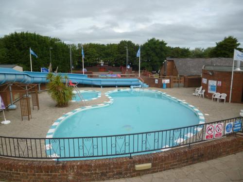a large swimming pool with a fence around it at Lower Hyde Caravan in Shanklin