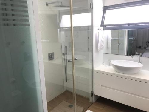 a bathroom with a glass shower and a sink at Charming Unit with Pool and Great Amenities in Rishon LeẔiyyon