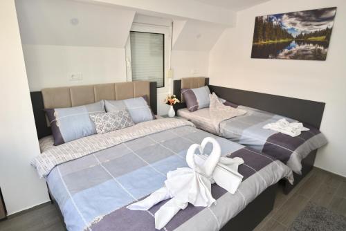 a bedroom with two beds with white bows on them at Kate Apartments in Ohrid