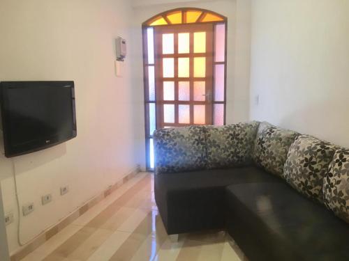 a living room with a couch and a tv at Hospedaria Ilhabela - Flats Balsa in Ilhabela