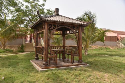 a gazebo with two benches in a yard at Hotel & Resort Golden Marina Yanbu in Yanbu