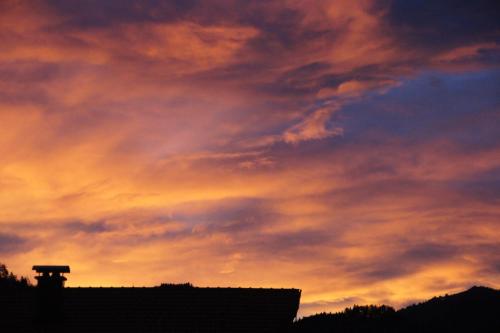 a sunset sky with a building in the foreground at Haus Lisa in Fuschl am See