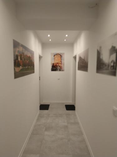 a hallway with paintings on the walls of a gallery at Lukas Guest Rooms in Kraków