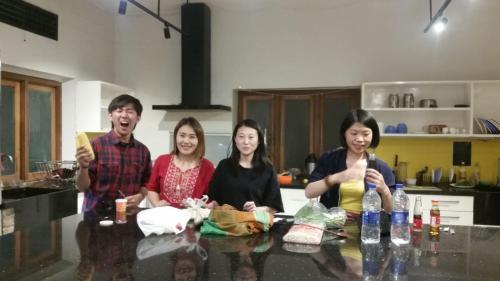 a group of people sitting at a table in a kitchen at THC Backpackers jodhpur in Jodhpur