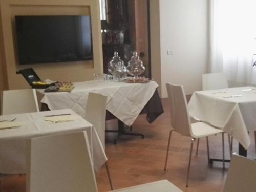 a dining room with white tables and white chairs at Locanda Al Portone in Scandiano