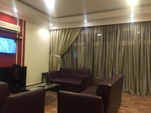 a living room with a couch and chairs and a television at Hotel & Resort Golden Marina Yanbu in Yanbu