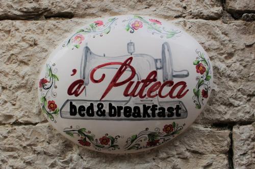 a sign for a pizza bed and breakfast on a wall at B&B 'A Puteca in San Marco dei Cavoti