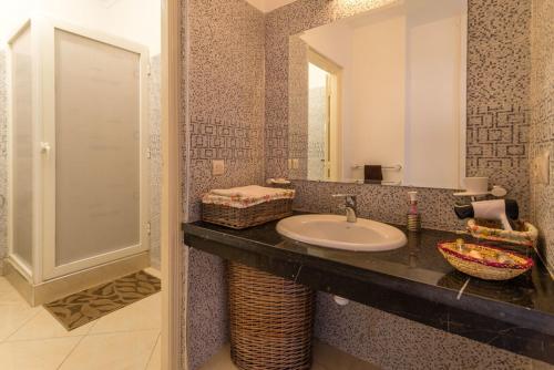 a bathroom with a sink and a mirror at Résidence Bab El Janoub in Ouarzazate