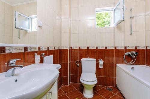a bathroom with a toilet and a sink and a tub at Villa Sladovic in Herceg-Novi