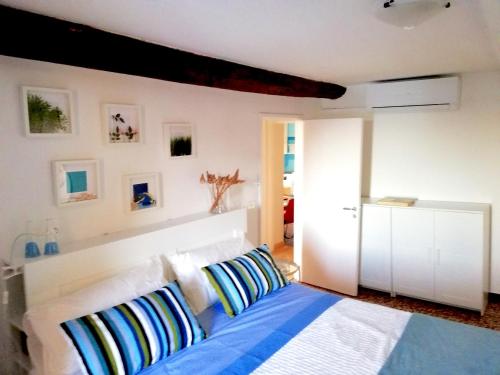 1 dormitorio con 1 cama con almohadas azules y blancas en Ancient Porticciolo - Nervi Genova, en Génova