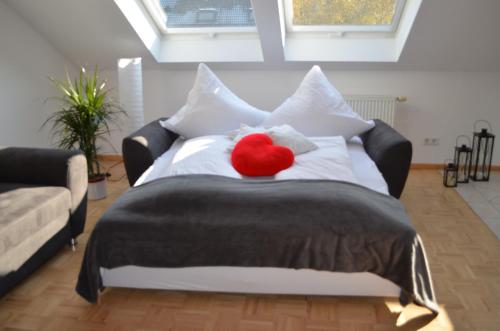 Una cama con un corazón rojo encima. en Ferienwohnung Schneckental en Pfaffenweiler