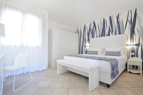 a bedroom with a large bed and a large window at Janna e Sole Resort in Budoni