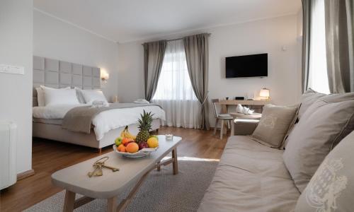 uma sala de estar com uma cama e uma mesa com fruta em Porto Vecchio Luxury Suites em Spetses