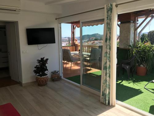a living room with a sliding glass door with a television at Apartment with private patio in Fuengirola