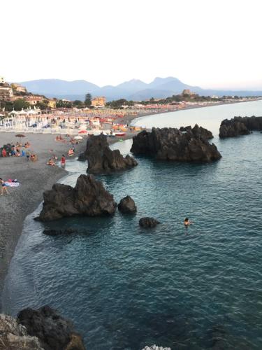 a group of people on a beach with rocks at B&B Magna Graecia in Scalea