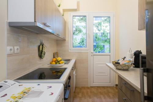 uma cozinha com um lavatório e uma taça de fruta no balcão em Acropolis Heart em Atenas