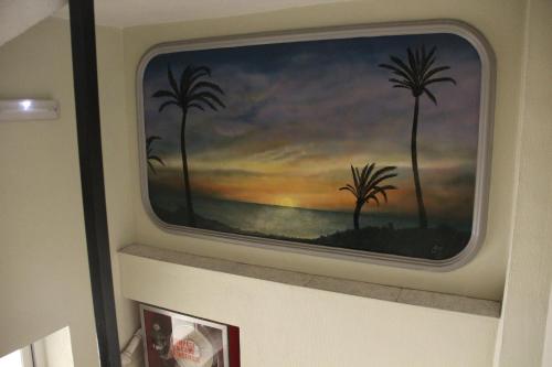 a painting of palm trees on a wall at Hotel Cano in Torrevieja