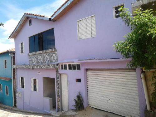 uma casa roxa com duas portas de garagem em Hospedaria Oliveira em São Tomé das Letras
