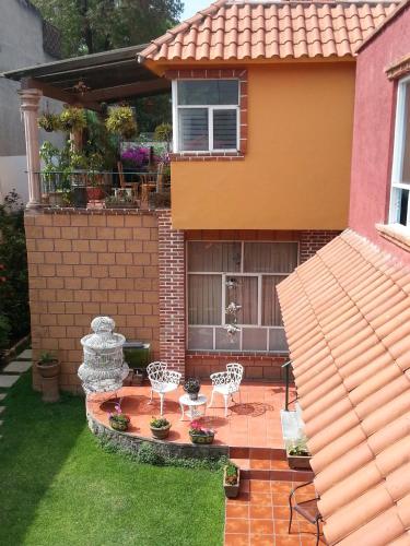 a house with a patio with two chairs and a table at Maria Del Alma House in Mexico City