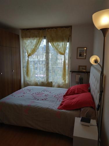 エクスレバンにあるLe Montcalmのベッドルーム1室(窓、ランプ付)