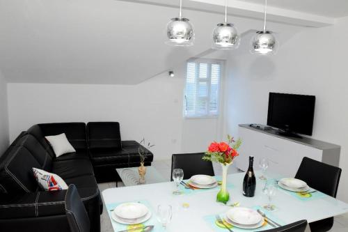 a living room with a white table and black chairs at Apartment Olive in Jovići