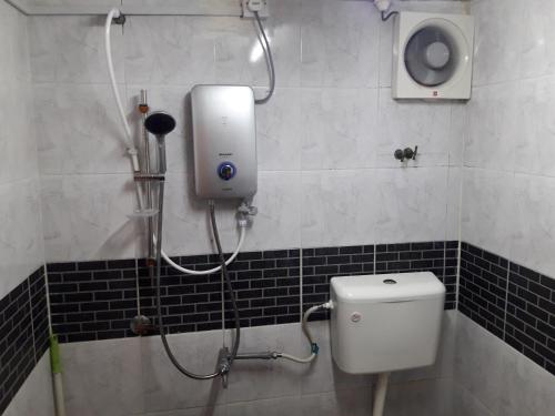a bathroom with a shower and a toilet in a room at Maznah Guest House in Cherating