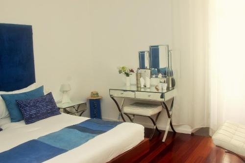 a bedroom with a bed and a desk with a mirror at Tavira House in Tavira