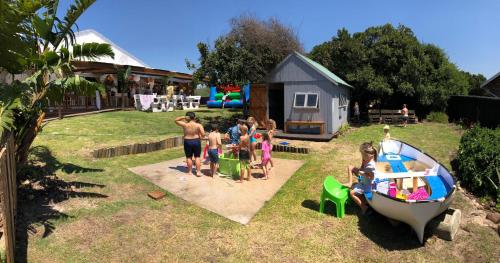 a group of children playing in a backyard with a boat at Cape St Francis Resort in Cape St Francis