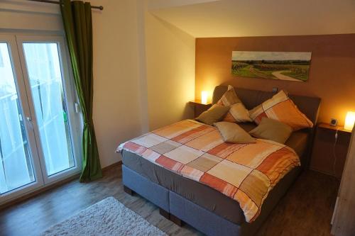 Un dormitorio con una cama y una ventana grande en Ferienwohnung Familie Westermann, en Kapellen-Drusweiler