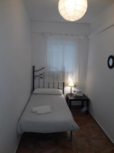sypialnia z łóżkiem i lampką na stole w obiekcie Cristinas Palace w Sewilli