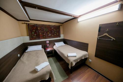 Habitación pequeña con 2 camas y ventana en Club-Hotel Flagman, en Bishkek