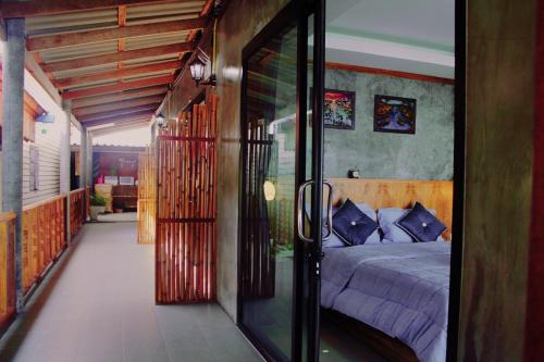 a bedroom with a bed and a glass doorway at Lanta Sabai Day House in Ko Lanta