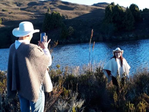 a man taking a picture of a woman by a lake at La cabaña de sol in Aquitania