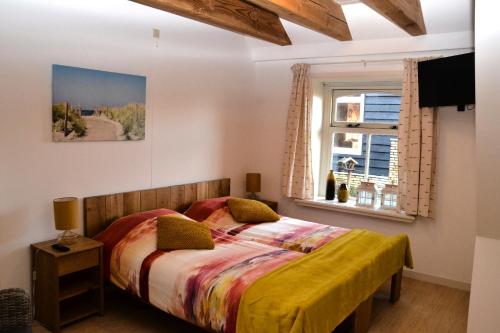 a bedroom with a bed and a window at B&B Idylle aan Zee incl 2 Wellnessstudios in Sint Maartensvlotbrug