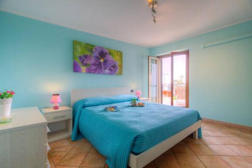 een blauwe slaapkamer met een bed met een blauwe deken bij Appartamento a pochi passi dal mare in Formia