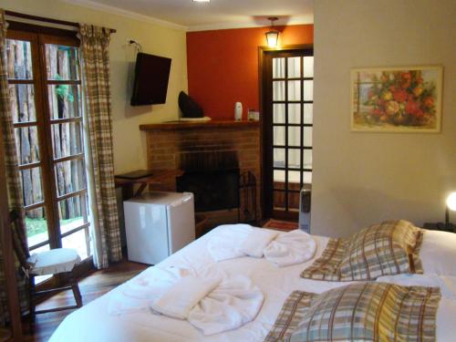 a bedroom with two beds and a fireplace at Alpenhaus Pousada in Campos do Jordão