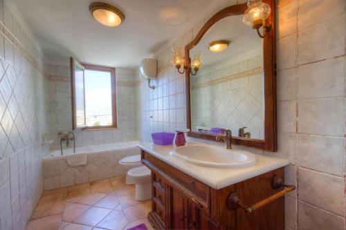 een badkamer met een wastafel, een toilet en een spiegel bij Appartamento a pochi passi dal mare in Formia