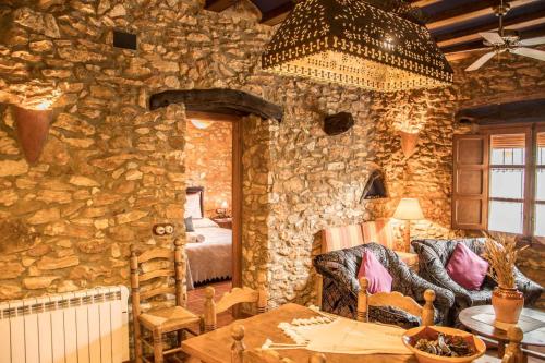 a stone walled room with a bed and a table at Amborget in Sant Jordi