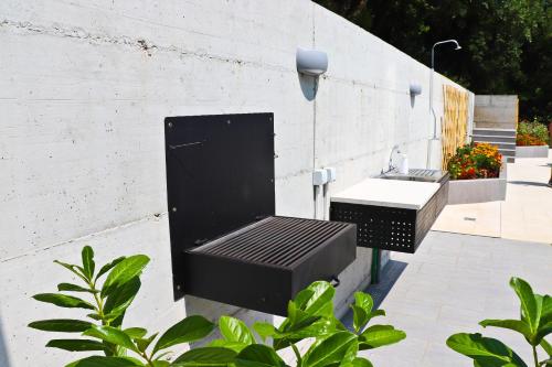 a black bench next to a sink on a wall at Villa Sladovic in Herceg-Novi