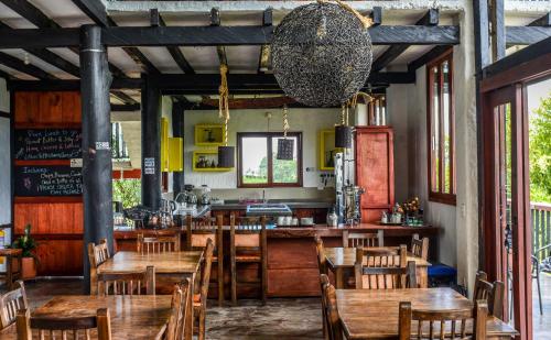 restauracja z drewnianymi stołami i krzesłami oraz bar w obiekcie Coffee Tree Boutique Hostel w mieście Salento
