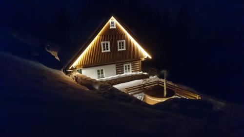 a house with a light on the roof in the snow at Kajzrovka in Rokytnice nad Jizerou