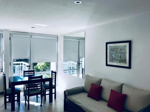 sala de estar con sofá y mesa de comedor en Marco Polo Perla Apartamento en Mar del Plata