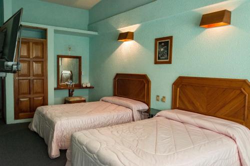 Cette chambre comprend deux lits et une télévision. dans l'établissement Hotel Michelle, à San Andrés Tuxtla