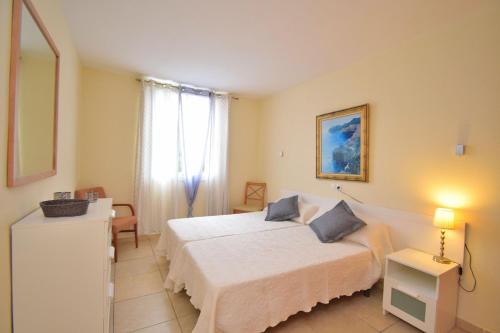 1 dormitorio con cama blanca y ventana en Apartamento Ca n'Antonia 092 by Mallorca Charme, en Can Picafort