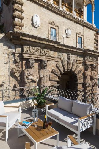 a brick wall with a couch and tables on a patio at I Mori di Porta Nuova Suite & Terrace in Palermo