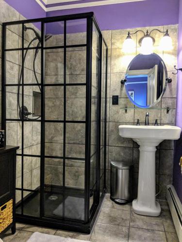 a bathroom with a shower and a sink and a mirror at Chelsea Pub and Inn in Atlantic City